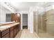 Well-lit bathroom with double sinks, walk-in shower, and tile flooring at 12450 Fish Cove Dr, Spring Hill, FL 34609