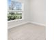 Cozy bedroom featuring a large window with views of the outdoors and neutral-colored tile flooring at 12450 Fish Cove Dr, Spring Hill, FL 34609