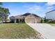 Charming single-story home featuring a three-car garage and a well-manicured front lawn at 12450 Fish Cove Dr, Spring Hill, FL 34609