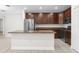 Kitchen with dark wood cabinets and a granite-topped island with stainless steel appliances at 12450 Fish Cove Dr, Spring Hill, FL 34609