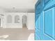 Bright foyer with a blue front door leading into a spacious living area with tiled flooring and arched design elements at 1313 Gatewood Ave, Spring Hill, FL 34608