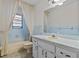 Bathroom with blue and white tiling, vanity with sink, and a shower-tub combo at 13820 Plumosa Ave, Hudson, FL 34667