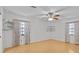 Bright bedroom with wood floors, ceiling fan, two windows, and built-in shelving at 13820 Plumosa Ave, Hudson, FL 34667