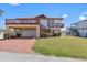 Two-story home with a two-car garage, balconies, landscaped lawn, and a stairway to the upper floor at 13820 Plumosa Ave, Hudson, FL 34667