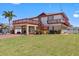 Charming two-story waterfront home with a two-car garage, balconies, and well-manicured lawn at 13820 Plumosa Ave, Hudson, FL 34667
