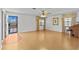 Open living room with hardwood floors, ceiling fan, and natural light from two windows at 13820 Plumosa Ave, Hudson, FL 34667