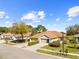 Aerial view of a well-manicured property with a green lawn, mature trees, and a spacious driveway at 14471 Sterling Run, Spring Hill, FL 34609