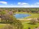 Scenic aerial view of a golf course featuring a tranquil pond and lush green landscape at 14471 Sterling Run, Spring Hill, FL 34609