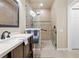 Bright bathroom featuring a glass-enclosed shower, dark wood vanity, and neutral-toned tile flooring at 14471 Sterling Run, Spring Hill, FL 34609
