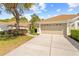 Exterior shot of home featuring a driveway leading to a two-car garage and landscaped surroundings at 14471 Sterling Run, Spring Hill, FL 34609
