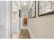 Hallway features neutral walls, tile flooring, framed photos, and doors leading to other rooms at 14471 Sterling Run, Spring Hill, FL 34609
