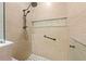 Walk-in shower boasts a mosaic floor, a built-in shelf, sleek fixtures, and large, neutral-toned tiles at 14471 Sterling Run, Spring Hill, FL 34609