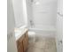 A bright bathroom with a shower-tub combination and neutral-toned tile flooring at 14656 Wake Robin Dr, Brooksville, FL 34604