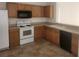 Functional kitchen features tile flooring, white appliances, and light wood cabinetry at 14656 Wake Robin Dr, Brooksville, FL 34604