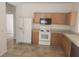 Functional kitchen features tile flooring, white appliances, and light wood cabinetry at 14656 Wake Robin Dr, Brooksville, FL 34604