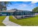 Backyard featuring a pool with screened enclosure and lush lawn at 15193 Copeland Way, Brooksville, FL 34604