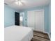 Serene bedroom with light blue walls, luxury vinyl plank flooring, large closets, and a door leading to another room at 15193 Copeland Way, Brooksville, FL 34604