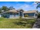 Home exterior with a lush green lawn and landscaping. Featuring concrete accents and a tile roof at 15193 Copeland Way, Brooksville, FL 34604