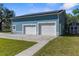 Exterior view of blue garage with solar panels and two white garage doors at 15193 Copeland Way, Brooksville, FL 34604