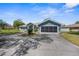 Home exterior showcasing a well-manicured lawn, a screened garage, and a concrete driveway at 15193 Copeland Way, Brooksville, FL 34604