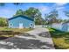 Exterior view of blue house with white trim, long driveway, and well manicured lawn at 15193 Copeland Way, Brooksville, FL 34604