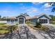 Charming single story home features a lovely blue exterior and well maintained front yard with mature landscaping and lovely walkway at 15193 Copeland Way, Brooksville, FL 34604
