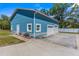Exterior of blue detached garage with two white garage doors and long drive at 15193 Copeland Way, Brooksville, FL 34604