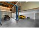 Spacious garage with an automotive lift, motorcycle, and a yellow sports car at 15193 Copeland Way, Brooksville, FL 34604