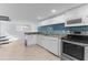 Renovated kitchen with white cabinets, blue backsplash, stainless appliances, and tile floors at 15193 Copeland Way, Brooksville, FL 34604