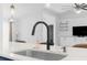 Kitchen sink featuring quartz countertop and matte black faucet, leading to open living area at 15193 Copeland Way, Brooksville, FL 34604