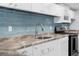 Modern kitchen with white cabinets, gray countertops, and stainless steel sink at 15193 Copeland Way, Brooksville, FL 34604