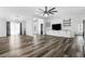 Bright living room with modern wood-look flooring, featuring built-in shelves, ceiling fan, and an open floor plan at 15193 Copeland Way, Brooksville, FL 34604