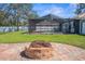 Backyard with screened in pool, brick fire pit, and green grass at 15193 Copeland Way, Brooksville, FL 34604