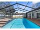 This in-ground pool features a screened enclosure, spa, and brick paver patio at 15193 Copeland Way, Brooksville, FL 34604