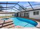View of a covered in-ground pool and brick paver patio at 15193 Copeland Way, Brooksville, FL 34604