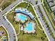 Aerial view of the community clubhouse with pools, parking, and surrounding roadways at 15793 Midnight Dove Ct, Odessa, FL 33556