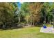 Serene backyard featuring a lush green lawn with stone retaining wall and mature trees offering privacy at 15793 Midnight Dove Ct, Odessa, FL 33556