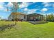 A wide shot of the home's backyard featuring the screened-in patio and grill at 15793 Midnight Dove Ct, Odessa, FL 33556
