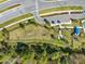 An aerial view of a fenced dog park is shown with trees, lush green grass, benches, play structures, and walking paths at 15793 Midnight Dove Ct, Odessa, FL 33556