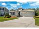 Charming single-Gathering home with a two-car garage, stone accents, lush landscaping, and a well-manicured lawn at 15793 Midnight Dove Ct, Odessa, FL 33556
