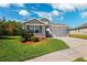 A charming single-Gathering home is shown, featuring a two-car garage, neutral paint, and a well-manicured lawn and landscaping at 15793 Midnight Dove Ct, Odessa, FL 33556