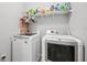 Bright laundry room with modern washer and dryer units and overhead storage shelf at 15793 Midnight Dove Ct, Odessa, FL 33556