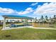 Outdoor picnic area with a covered shelter, picnic tables, and a playground with swings in a grassy area at 15793 Midnight Dove Ct, Odessa, FL 33556