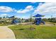 Community playground featuring colorful equipment, shade canopies, and a wood chip surface at 15793 Midnight Dove Ct, Odessa, FL 33556