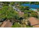 Aerial view of clustered homes near a serene lake with a fountain, complemented by a community pool at 1737 Pine Ridge W Way # B-1, Palm Harbor, FL 34684