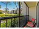 Screened in balcony with black railing and chairs overlooking green lawn at 1737 Pine Ridge W Way # B-1, Palm Harbor, FL 34684