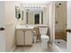 This bathroom includes a shower, bright mirror, and ample storage underneath the sink and in adjacent closets at 1737 Pine Ridge W Way # B-1, Palm Harbor, FL 34684