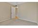 Neutral carpeted bedroom with tan walls and a white door leading to another room with wood flooring at 1737 Pine Ridge W Way # B-1, Palm Harbor, FL 34684