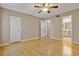 Bedroom with ceiling fan, smooth wood floors, and a view into an adjacent bathroom and closet at 1737 Pine Ridge W Way # B-1, Palm Harbor, FL 34684