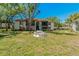 Exterior shot of condo building shows courtyard area with benches and umbrella at 1737 Pine Ridge W Way # B-1, Palm Harbor, FL 34684